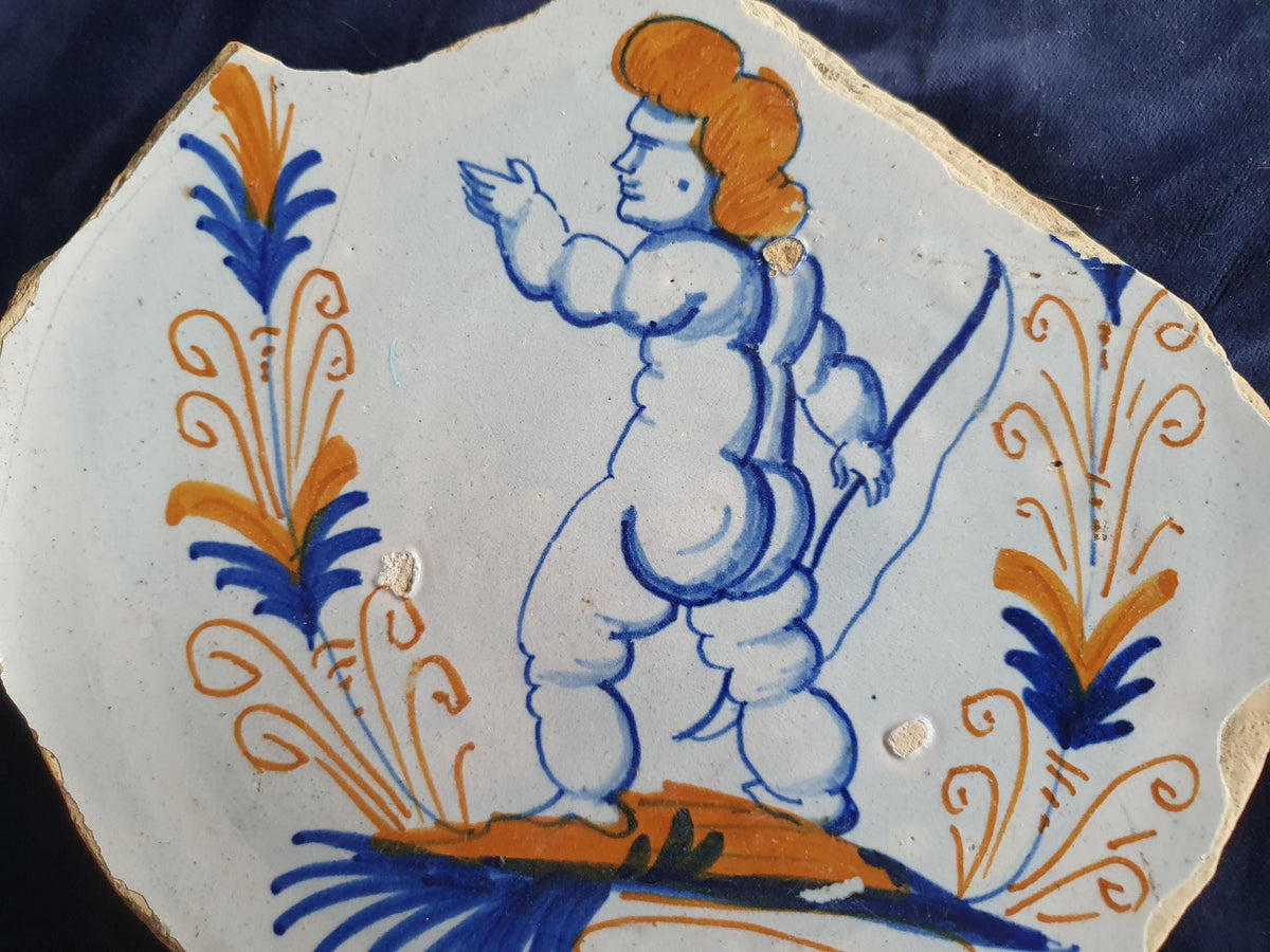 A rare, large shard from a plate, featuring a depiction on the base of a striding putto with a bow . 17th
