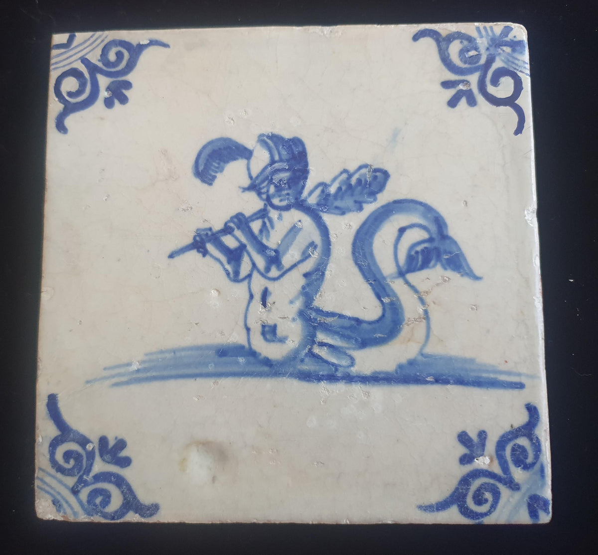 Antique Delft tile depicts a fierce looking merman holding a very large club. around 1660 mythicaltile