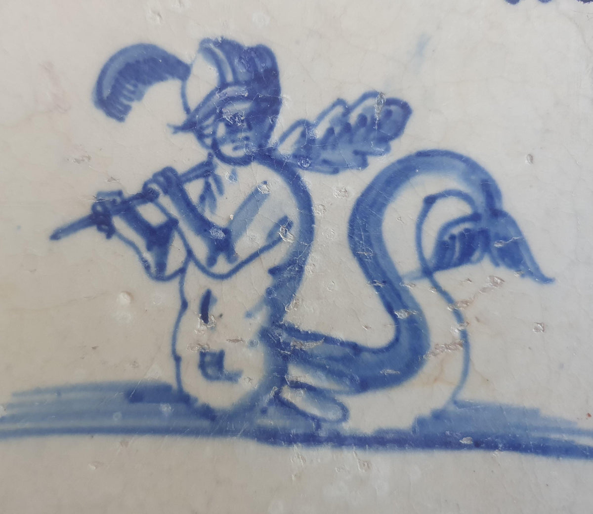 Antique Delft tile depicts a fierce looking merman holding a very large club. around 1660 mythicaltile