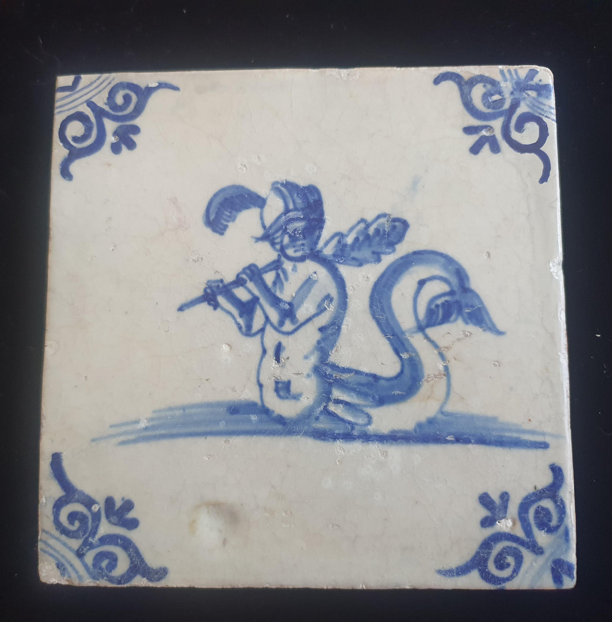 Antique Delft tile depicts a fierce looking merman holding a very large club. around 1660 mythicaltile