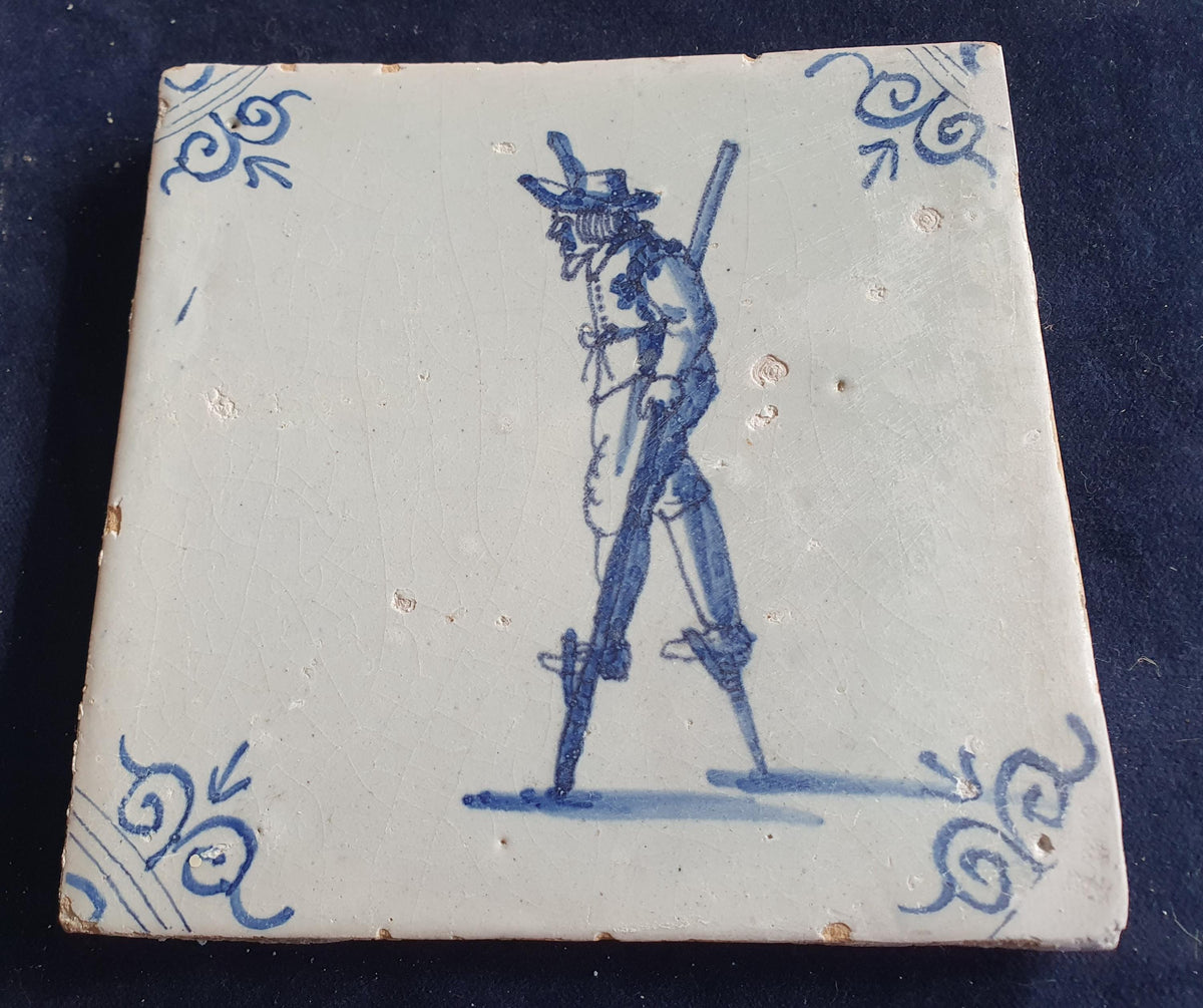 Antique Delft tile depicting a children's activity: walking on stilts.  Figuretile