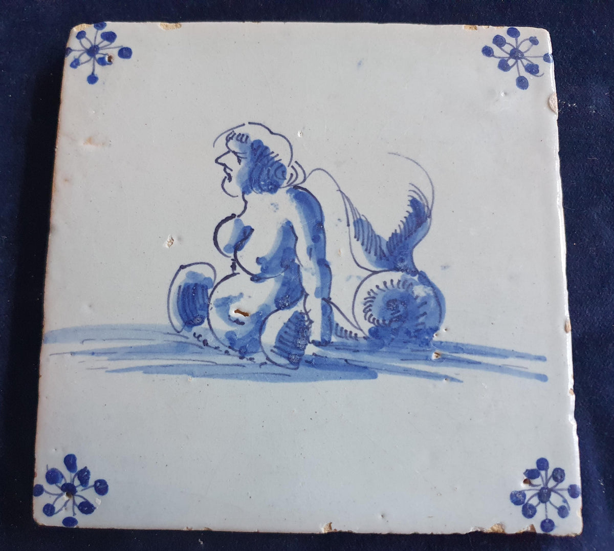 Delft tile with  a merman was produced around 1650 .  mythicaltile
