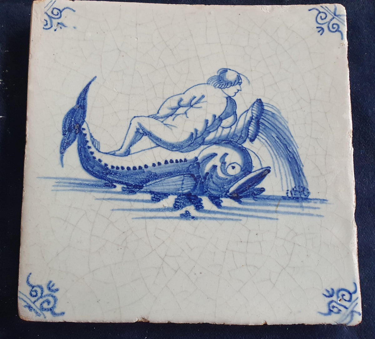 Delft tile depicts putti on top of dolphin. around 1660 mythicaltile