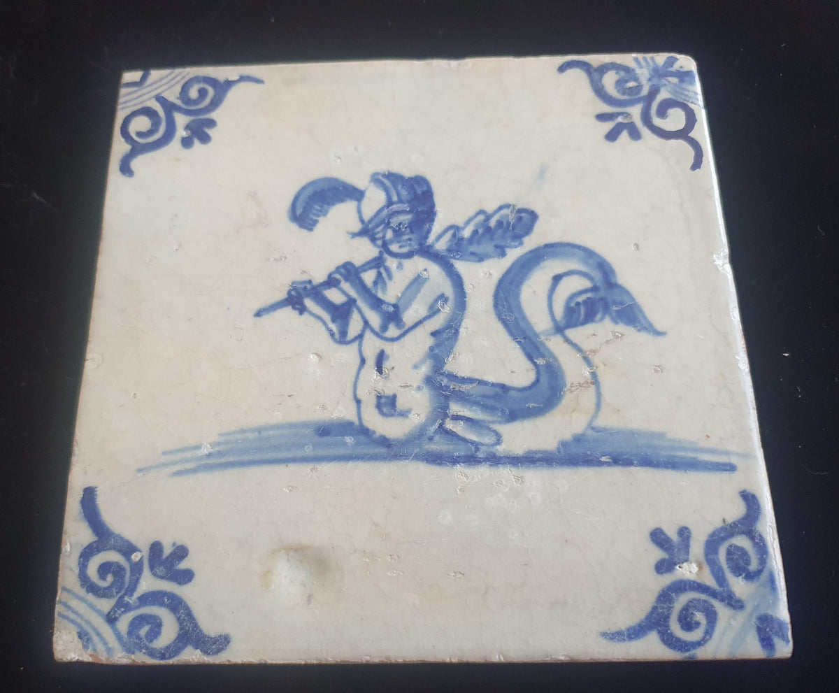 Antique Delft tile depicts a fierce looking merman holding a very large club. around 1660 mythicaltile