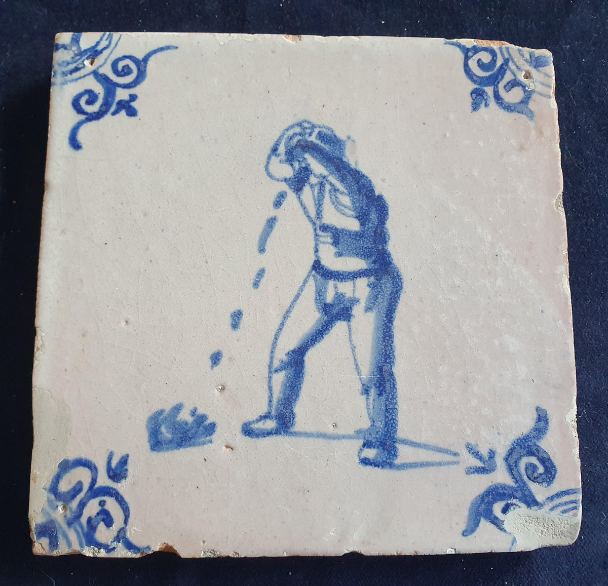 Antique Delft tile, dating from around 1650, depicts a man spitting. Figuretile