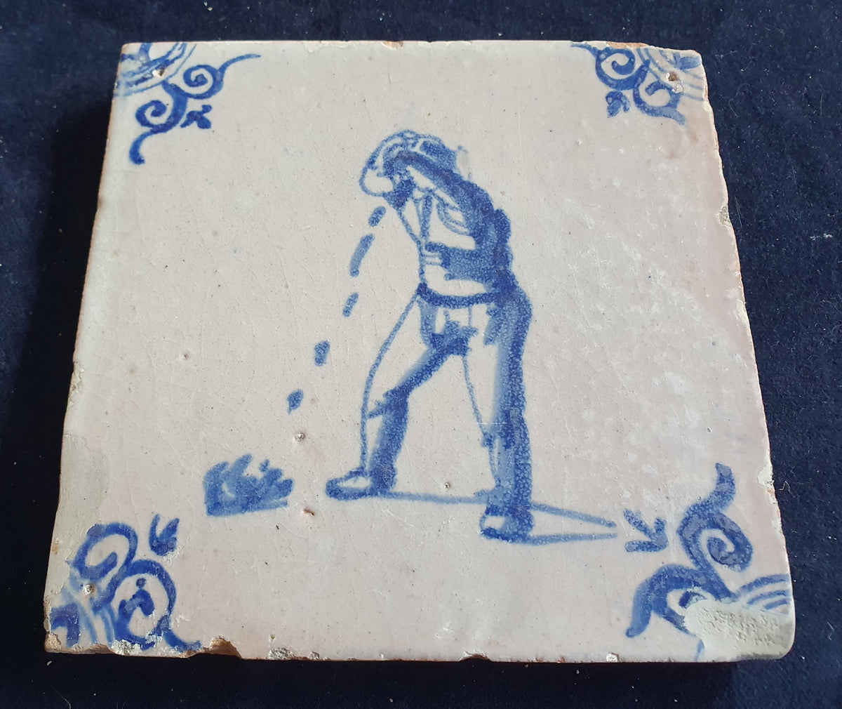 Antique Delft tile, dating from around 1650, depicts a man spitting. Figuretile