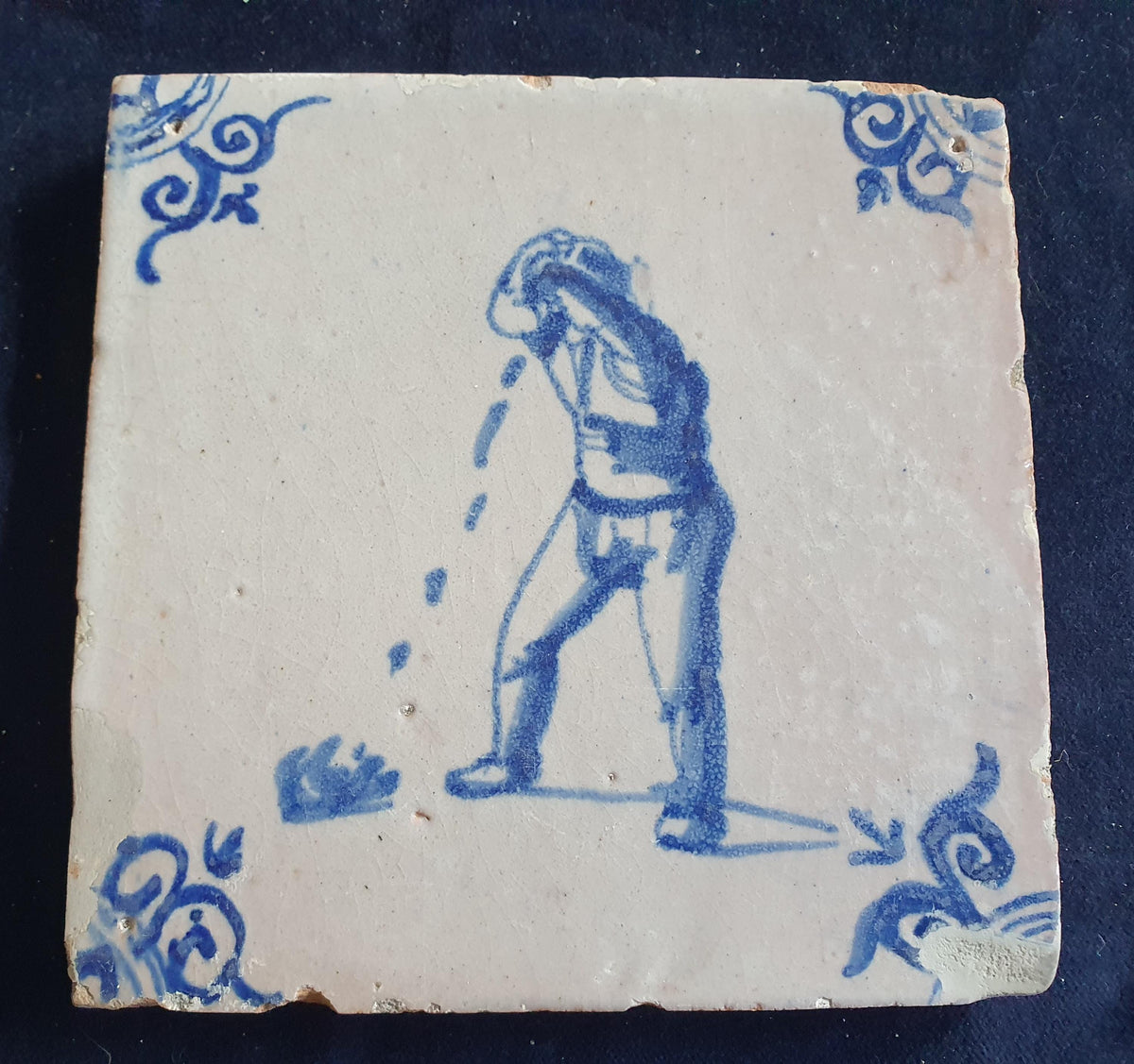 Antique Delft tile, dating from around 1650, depicts a man spitting. Figuretile