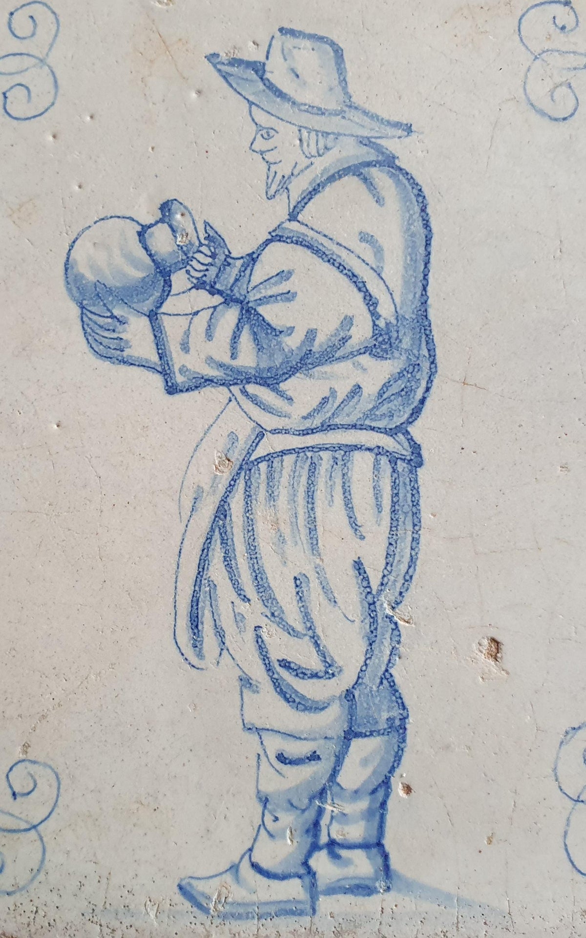 Antique Delft tile depicting a gentleman with a large jug—a so-called "drinker." Figuretile