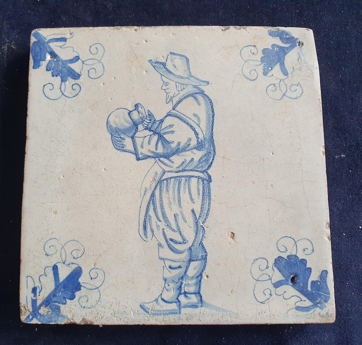 Antique Delft tile depicting a gentleman with a large jug—a so-called "drinker." Figuretile