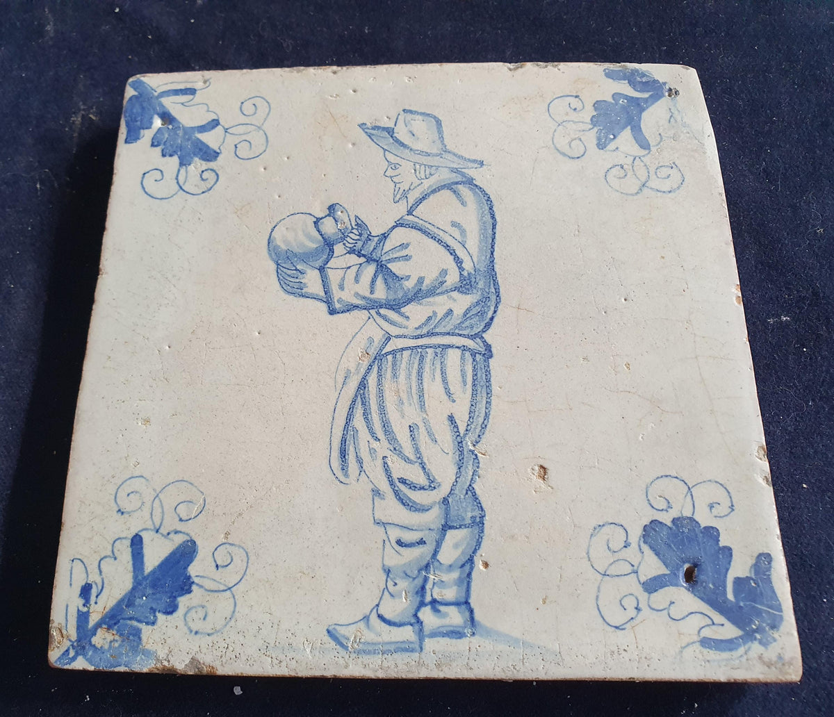 Antique Delft tile depicting a gentleman with a large jug—a so-called "drinker." Figuretile