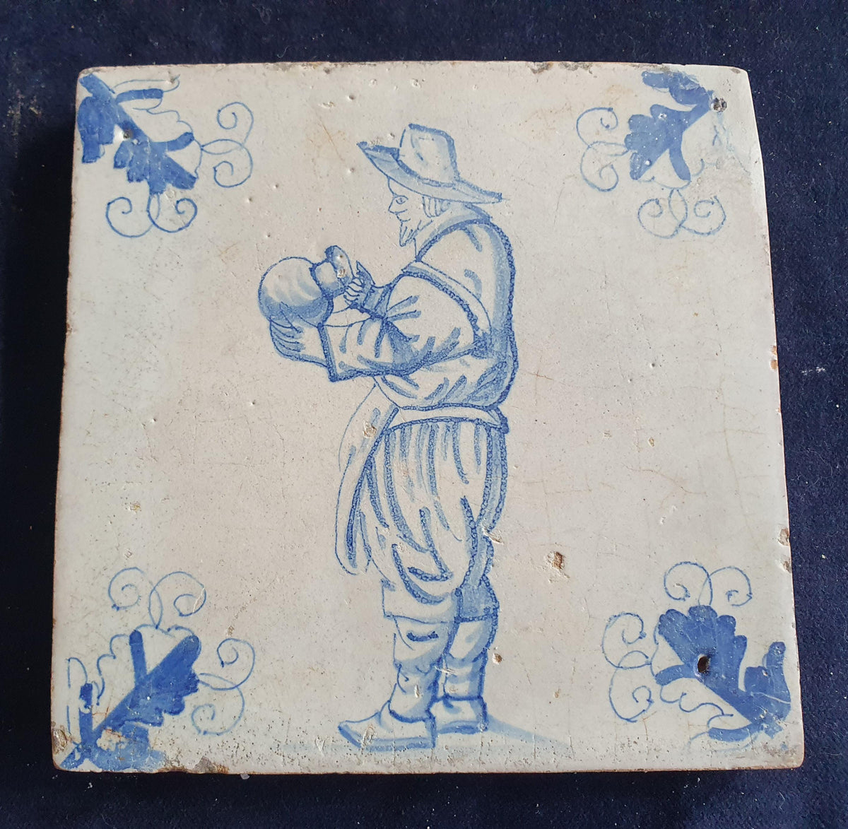 Antique Delft tile depicting a gentleman with a large jug—a so-called "drinker." Figuretile