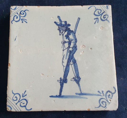 Antique Delft tile depicting a children's activity: walking on stilts.  Figuretile