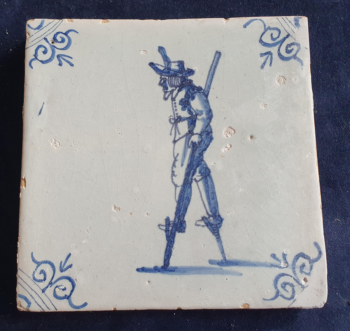 Antique Delft tile depicting a children's activity: walking on stilts.  Figuretile