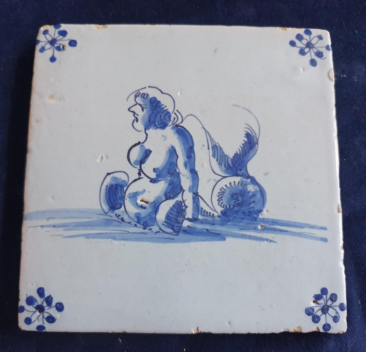 Delft tile with  a merman was produced around 1650 .  mythicaltile
