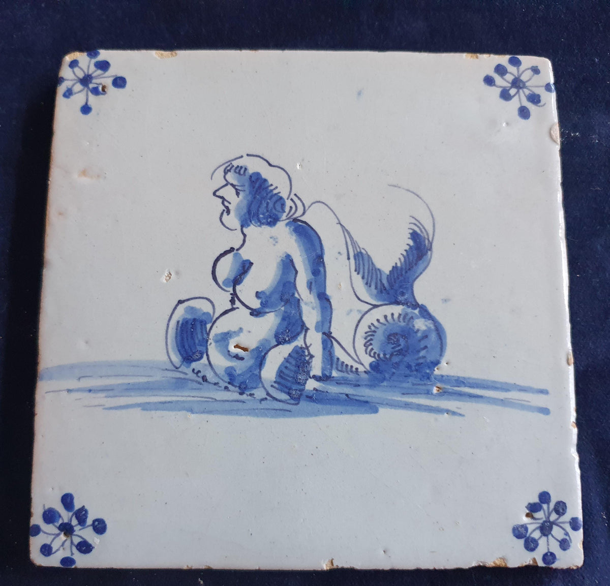 Delft tile with  a merman was produced around 1650 .  mythicaltile