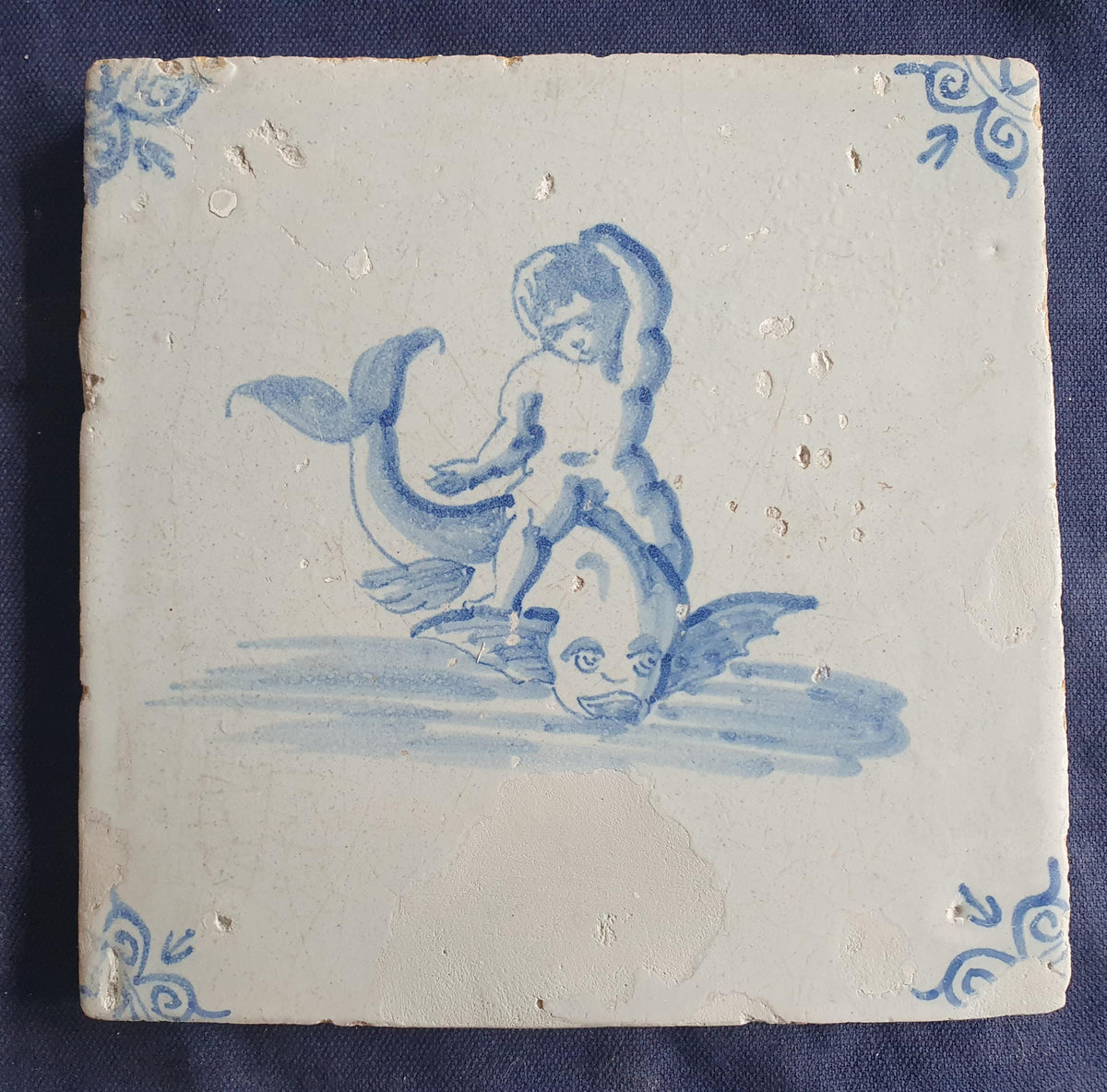 Antique magnificent tile, depicting Cupid riding a fish , is one of the rarest Delft tiles featuring Cupid. around 1640 faithtile