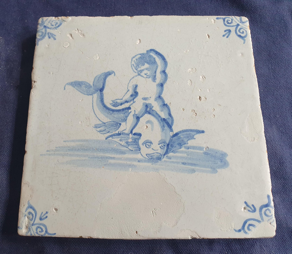 Antique magnificent tile, depicting Cupid riding a fish , is one of the rarest Delft tiles featuring Cupid. around 1640 faithtile
