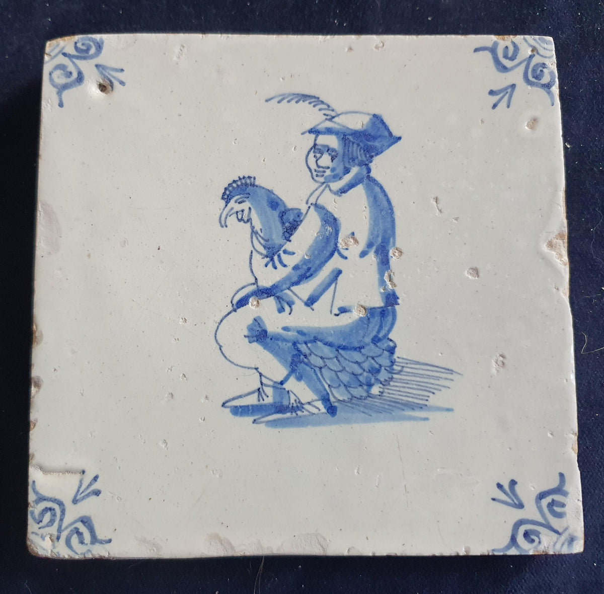 Antique Delft tile depicting a man with a chicken on his lap. around 1660 Figuretile