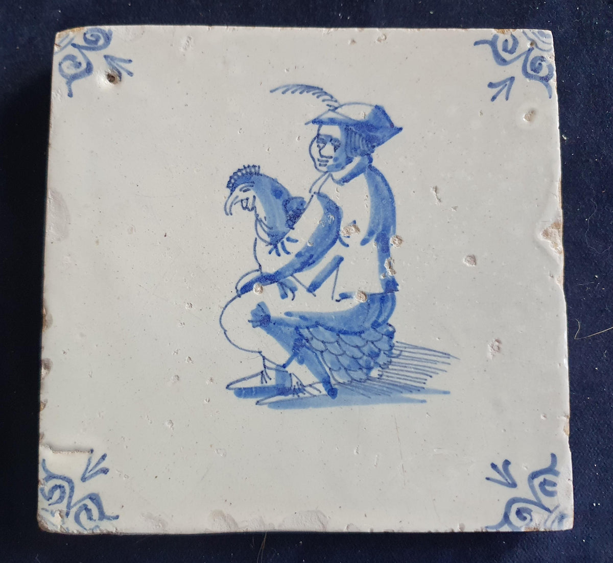 Antique Delft tile depicting a man with a chicken on his lap. around 1660 Figuretile