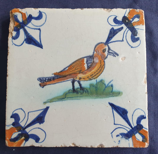 Wonderful tile depicting a beautiful colored bird in quite a size. Beautifully decorated with lily corner patterns.  Animaltile