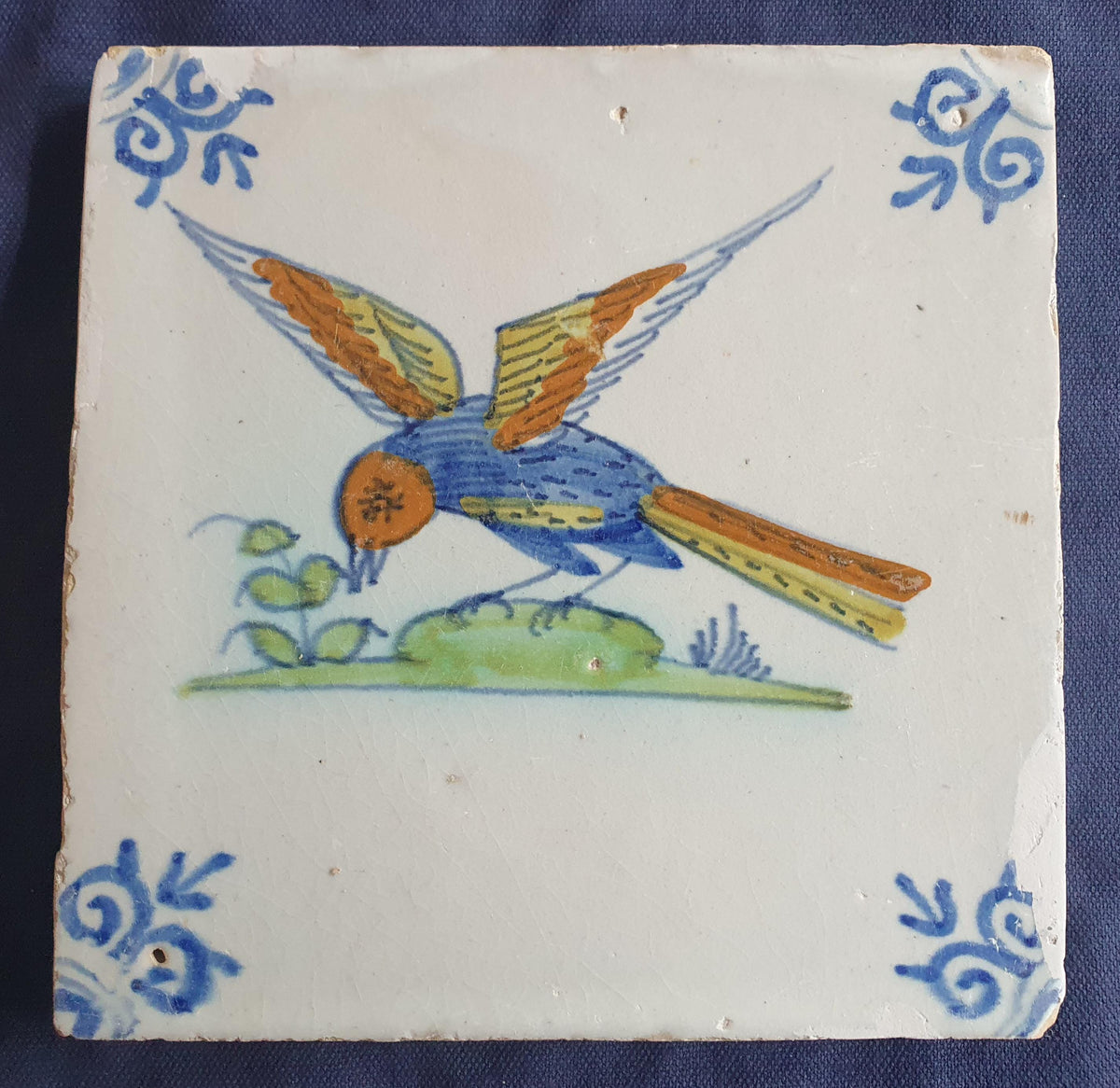 Delft tile depicting a colorful bird in flight, around 1640.  Animaltile