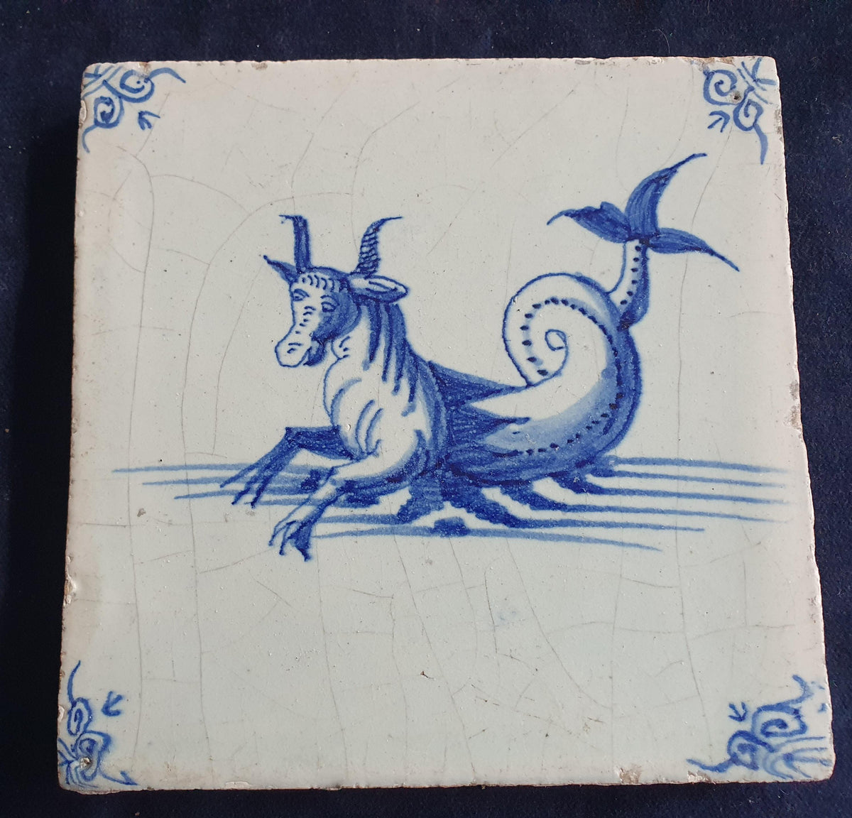 Antique Delft tile depicts a sea monster resembling a bul .  mythicaltile