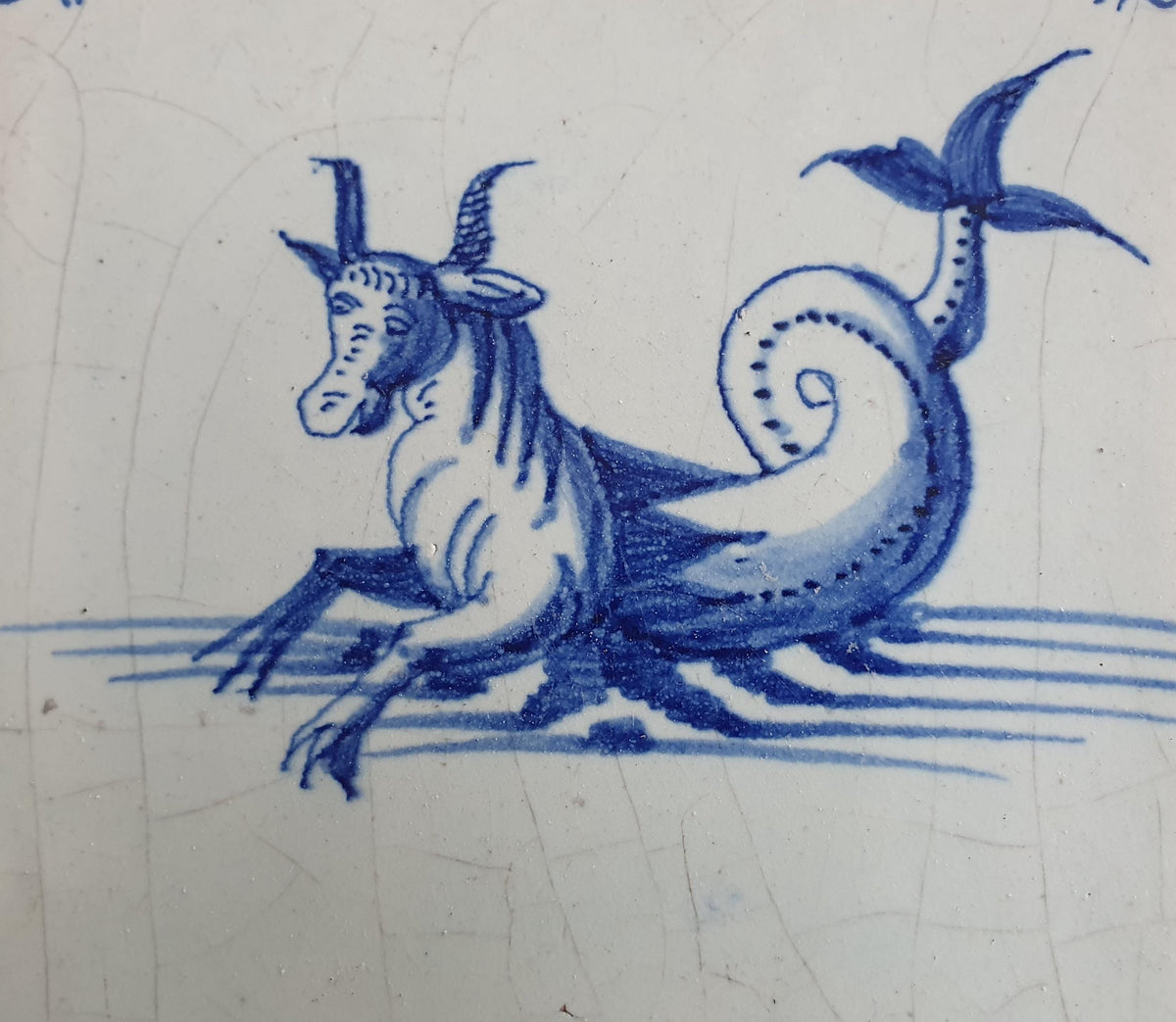 Antique Delft tile depicts a sea monster resembling a bul .  mythicaltile