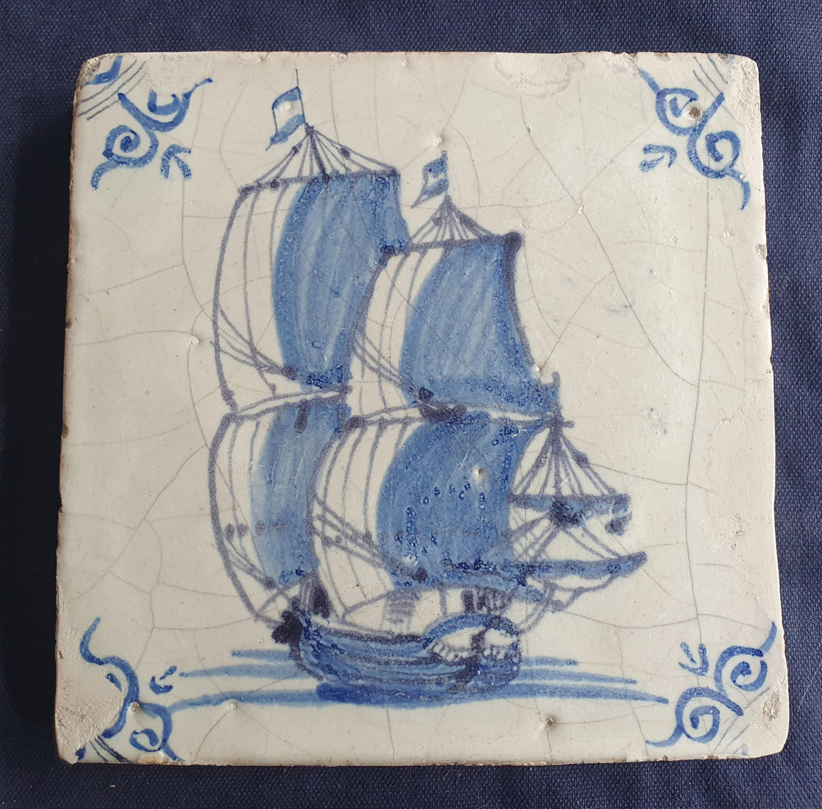 Antique Delft tile was made in Rotterdam around 1650 and depicts a sailing boat with fully hoisted sails. Shiptile