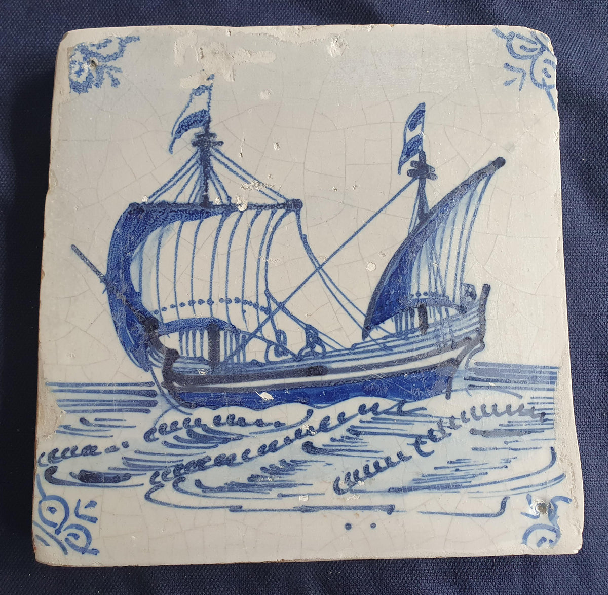 Delft tile, dating from circa 1660, is painted in blue and depicts a ship sailing to the left with its sails fully hoisted. Shiptile