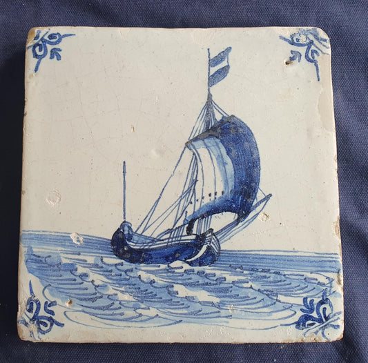 Delft tile, dating from circa 1660, is painted in blue and depicts a ship sailing. Shiptile