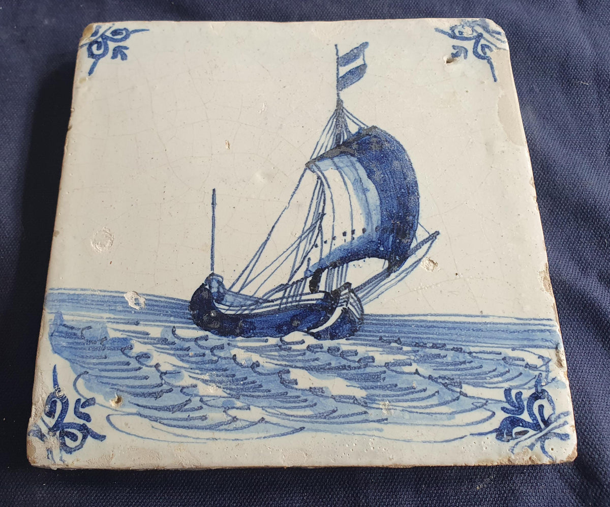 Delft tile, dating from circa 1660, is painted in blue and depicts a ship sailing. Shiptile