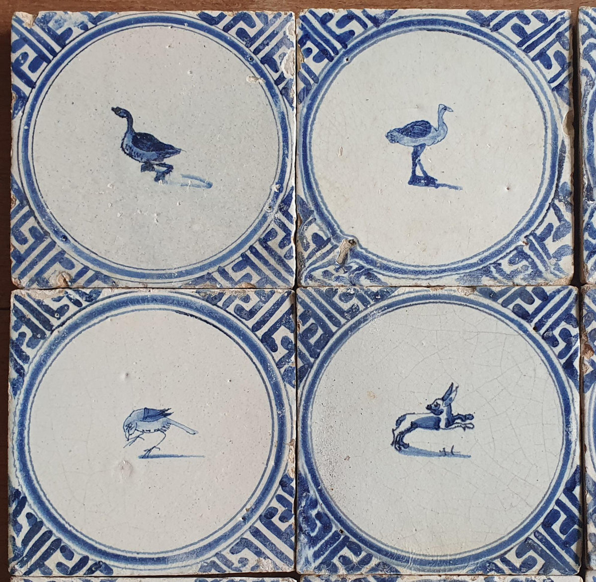 Sixteen antique Delft tiles feature designs within a circle.    Animaltile Wall tiles.