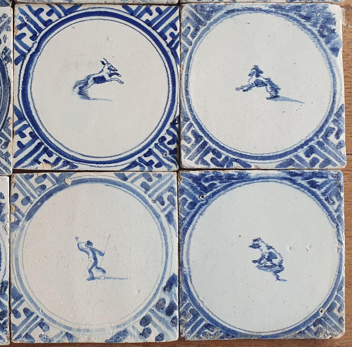 Sixteen antique Delft tiles feature designs within a circle.    Animaltile Wall tiles.