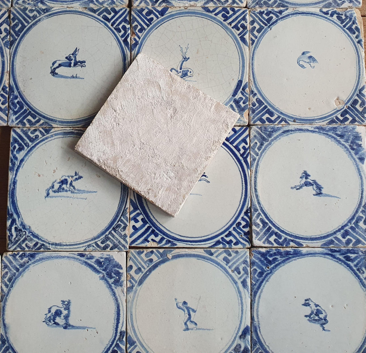 Sixteen antique Delft tiles feature designs within a circle.    Animaltile Wall tiles.