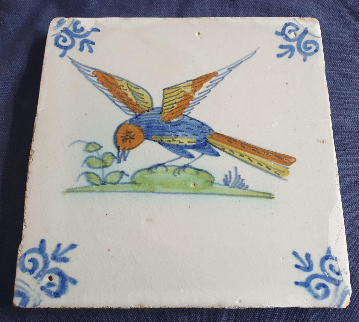 Delft tile depicting a colorful bird in flight, around 1640.  Animaltile