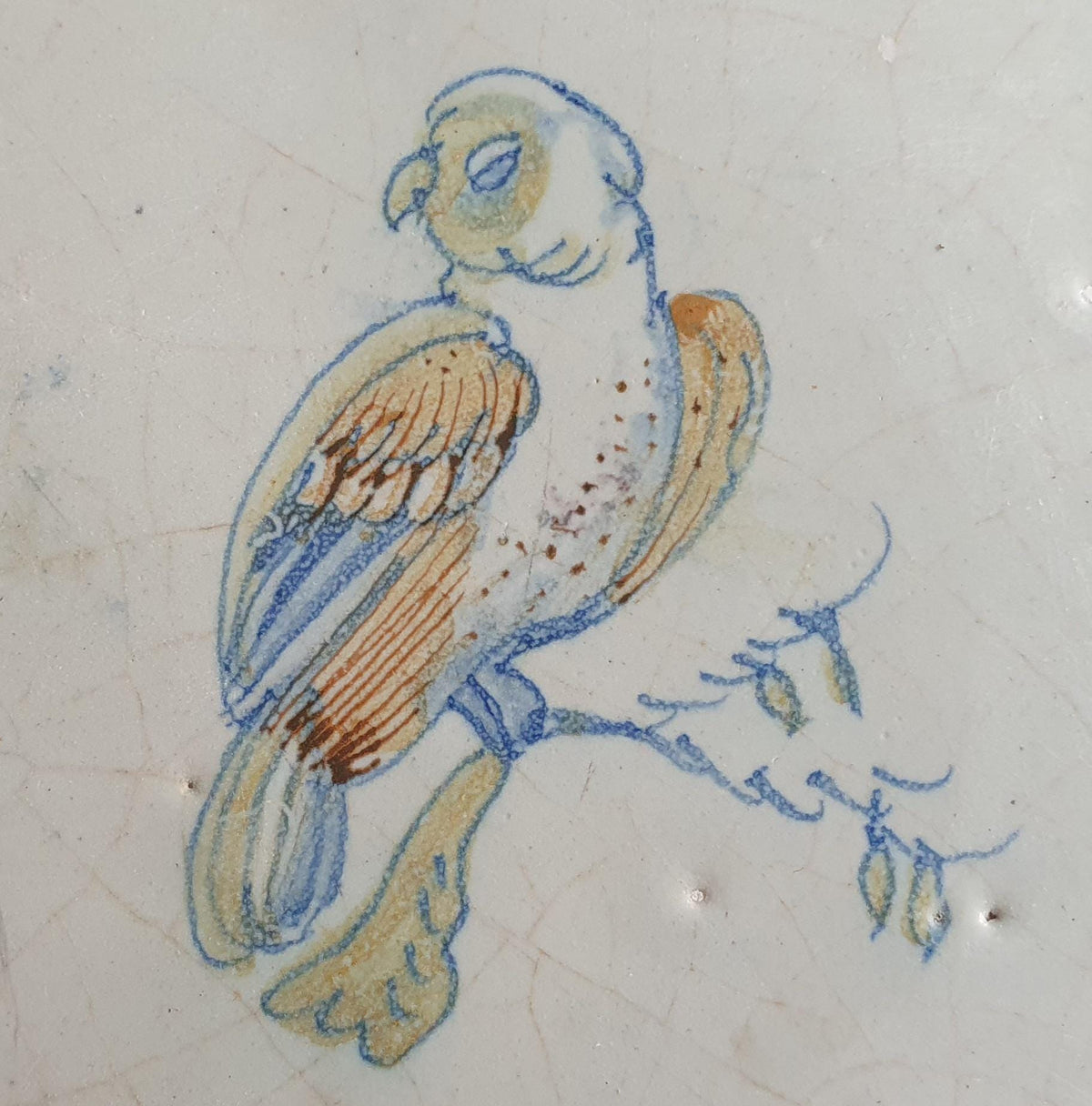 17th-century Delft tile, produced around 1640, featuring a beautifully painted parrot perched on a branch.  Animaltile