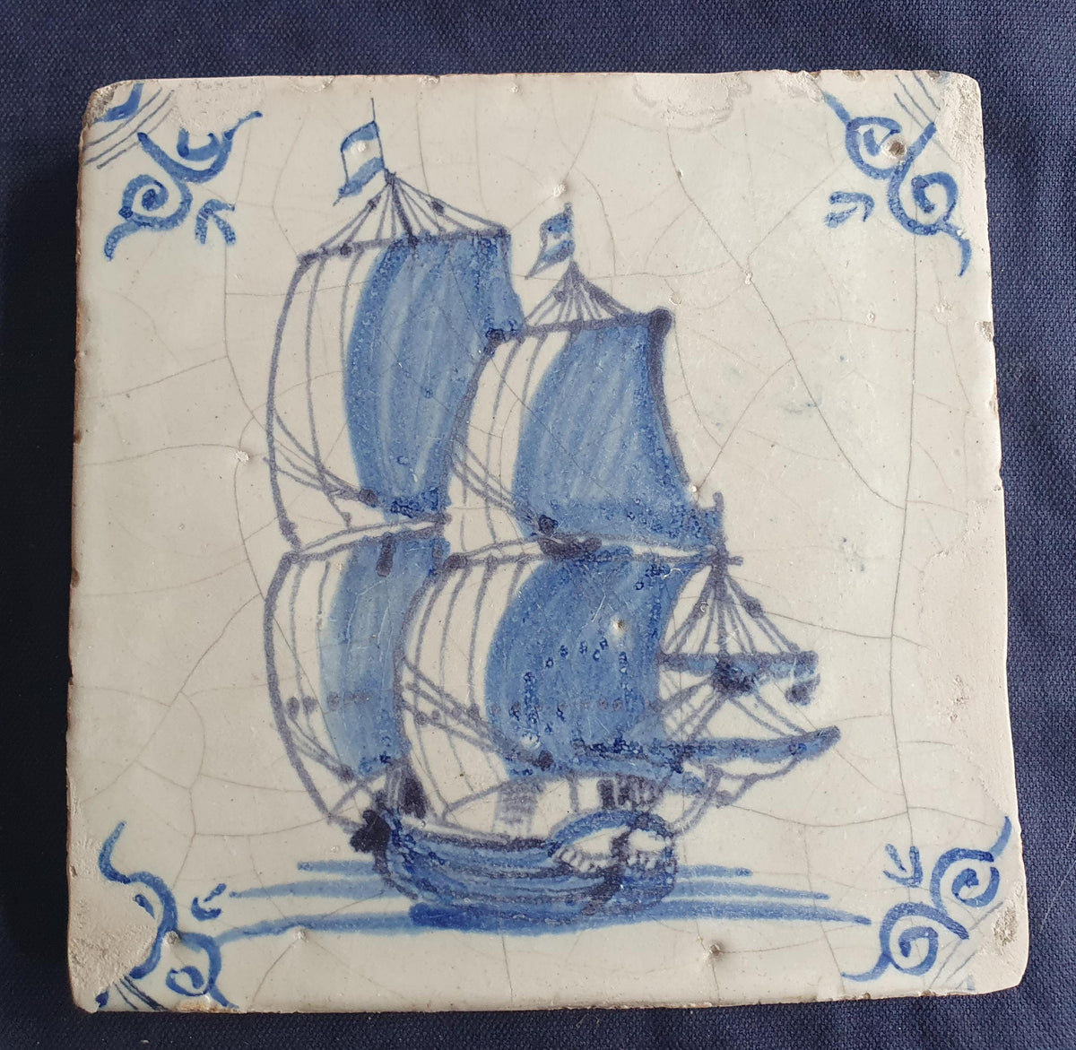 Antique Delft tile was made in Rotterdam around 1650 and depicts a sailing boat with fully hoisted sails. Shiptile