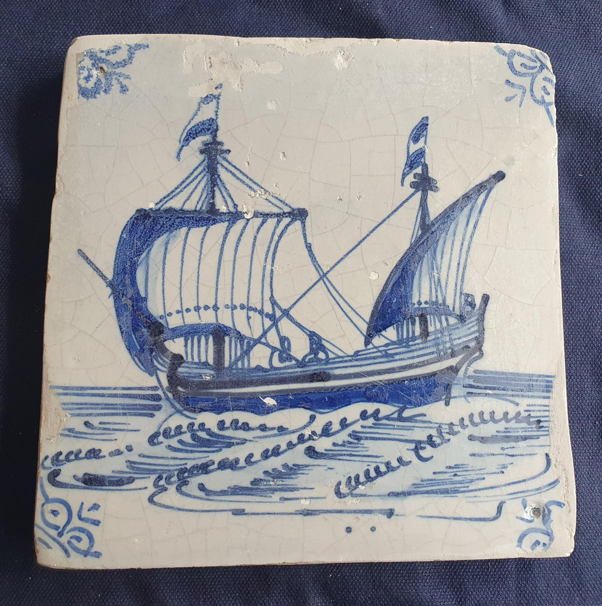 Delft tile, dating from circa 1660, is painted in blue and depicts a ship sailing to the left with its sails fully hoisted. Shiptile