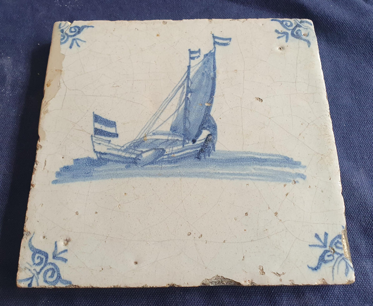 Delft tile, dating from circa 1660, is painted in blue and depicts a ship sailing. Shiptile